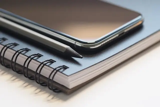 notebook, pen, and phone linking to blog and social media page